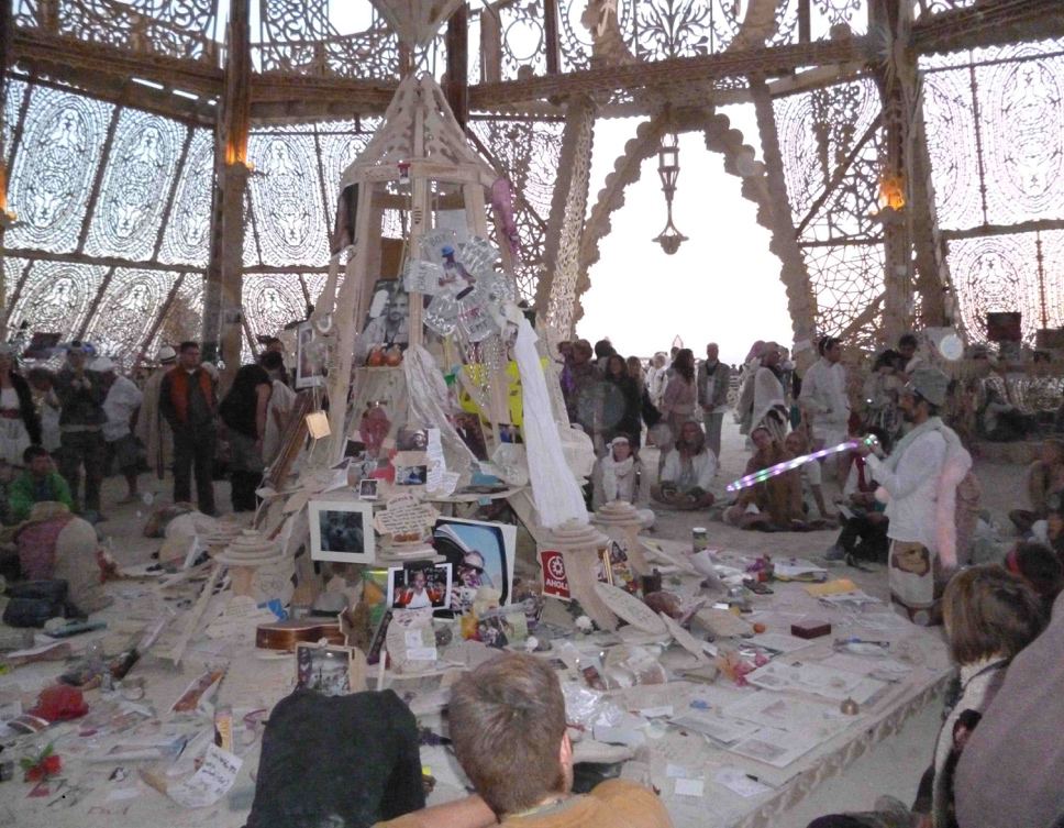 À l’intérieur du Temple of Grace, un burner agenouillé avec un cerceau LED. Burning Man,