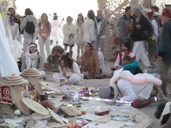 À l’intérieur du Temple of Grace, un burner agenouillé avec un cerceau LED. Burning Man,